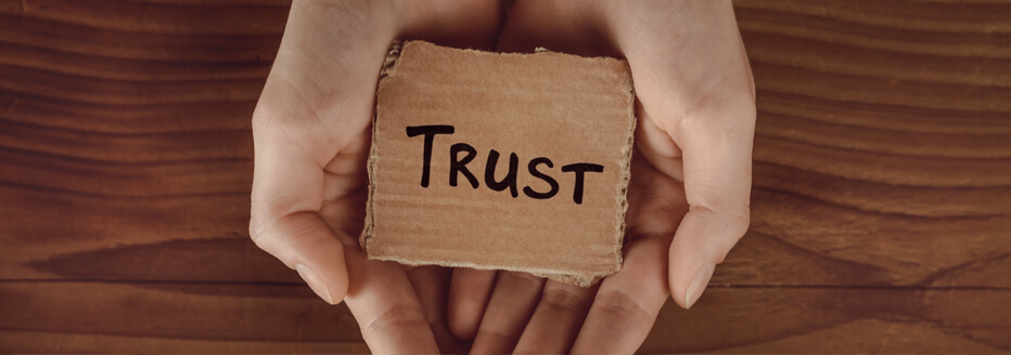 Two Hands holding a sign with the inscription Trust.